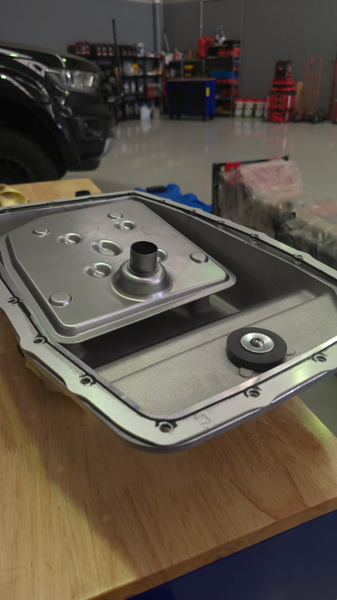 Inside the Auto Labs deep cast pan — deeper filter, drain plug, and dual internal magnet posts visible