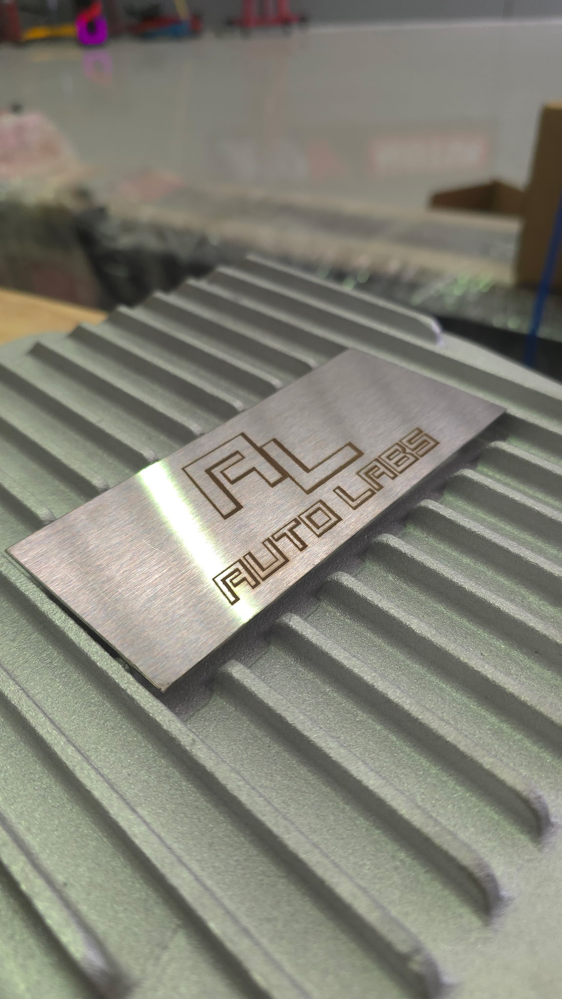Close-up of the laser-etched AL Auto Labs plate on the lid of the deep cast pan