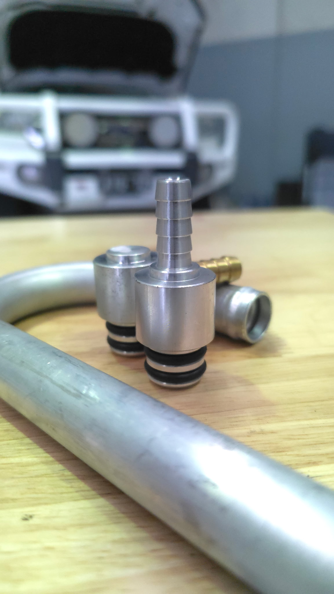 Custom-machined hose barb fittings for performance cooling lines