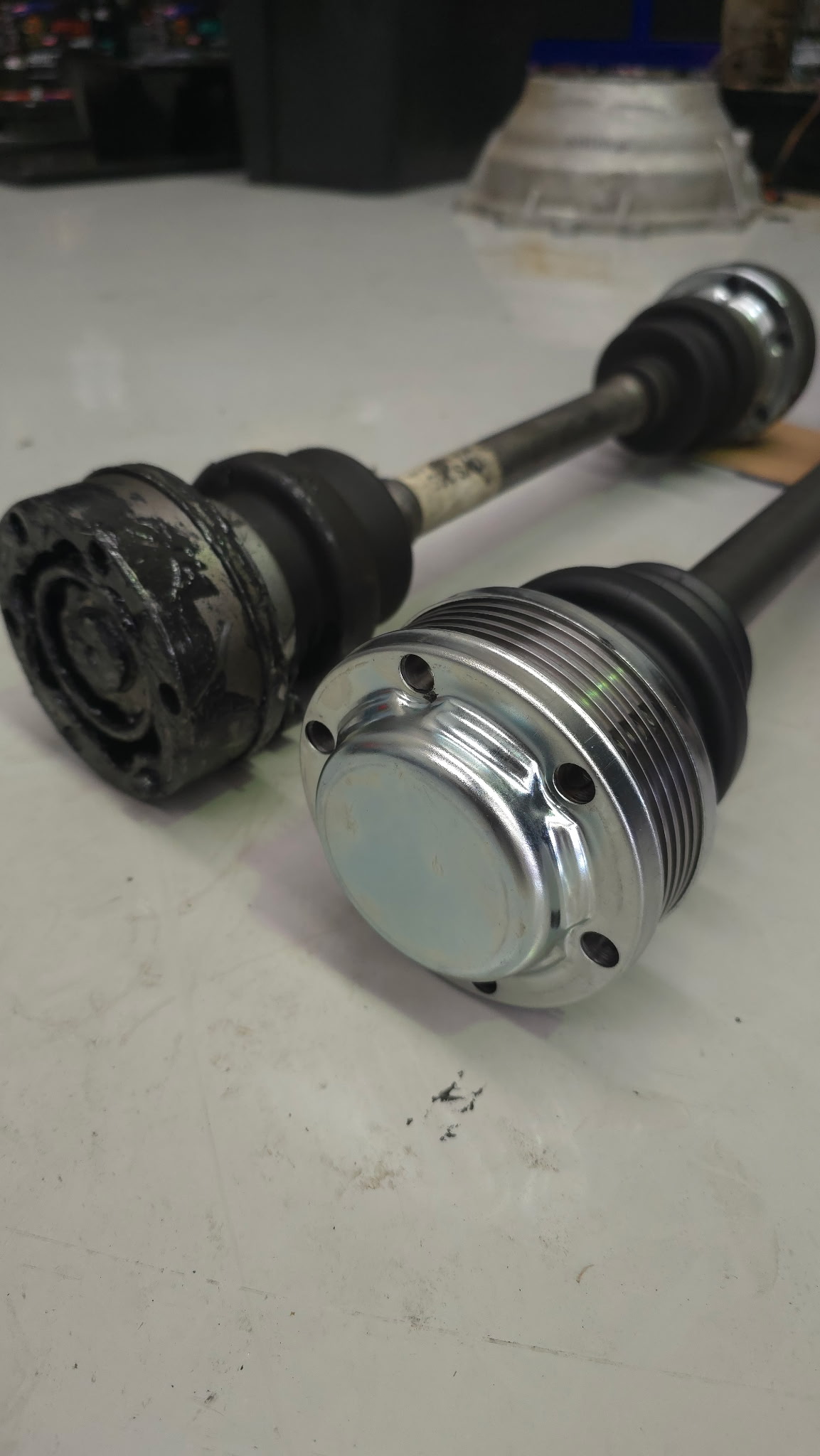 CV axle comparison — old worn joint vs new genuine replacement part